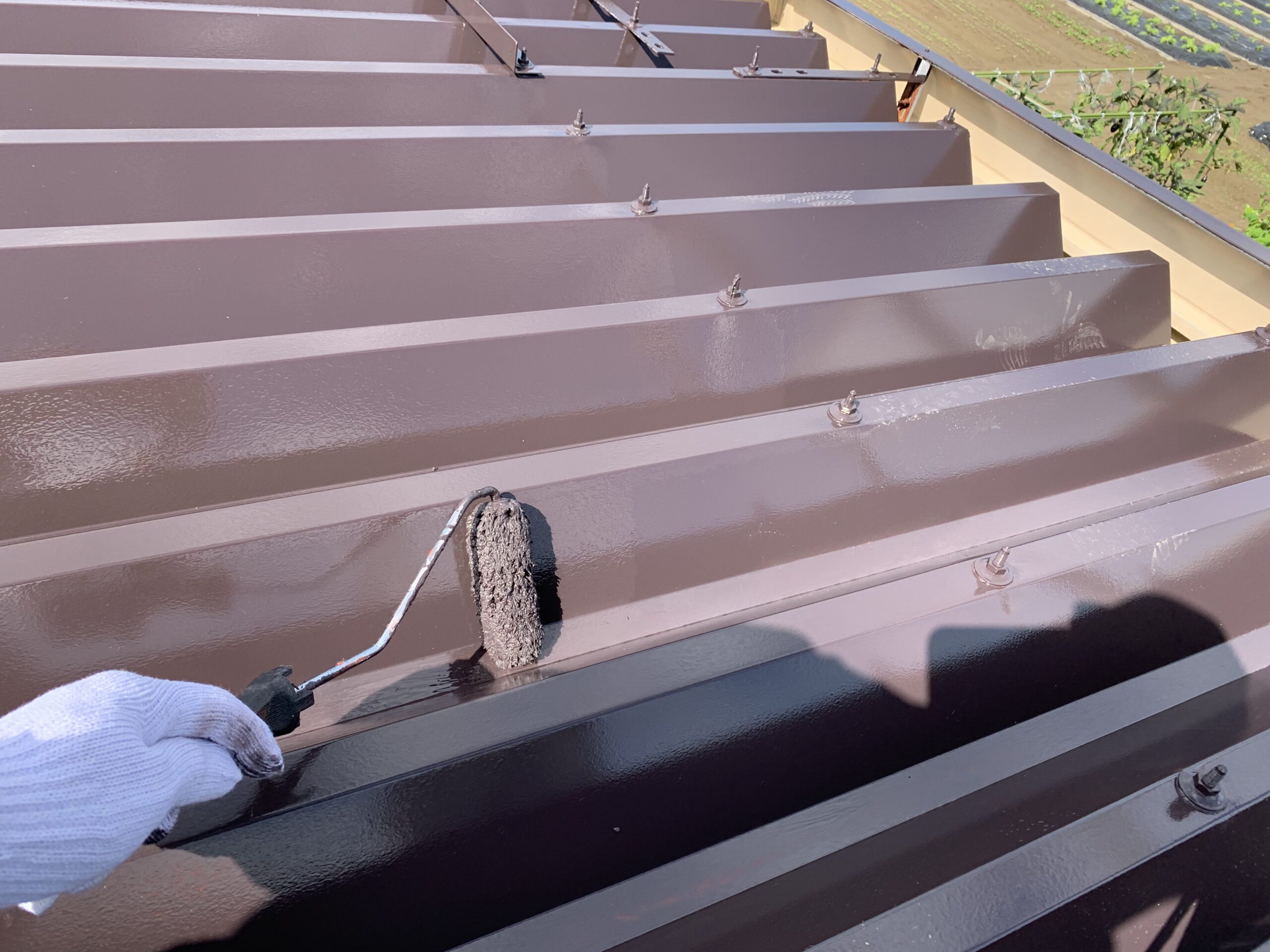 屋根の上塗り２回目を塗っている写真