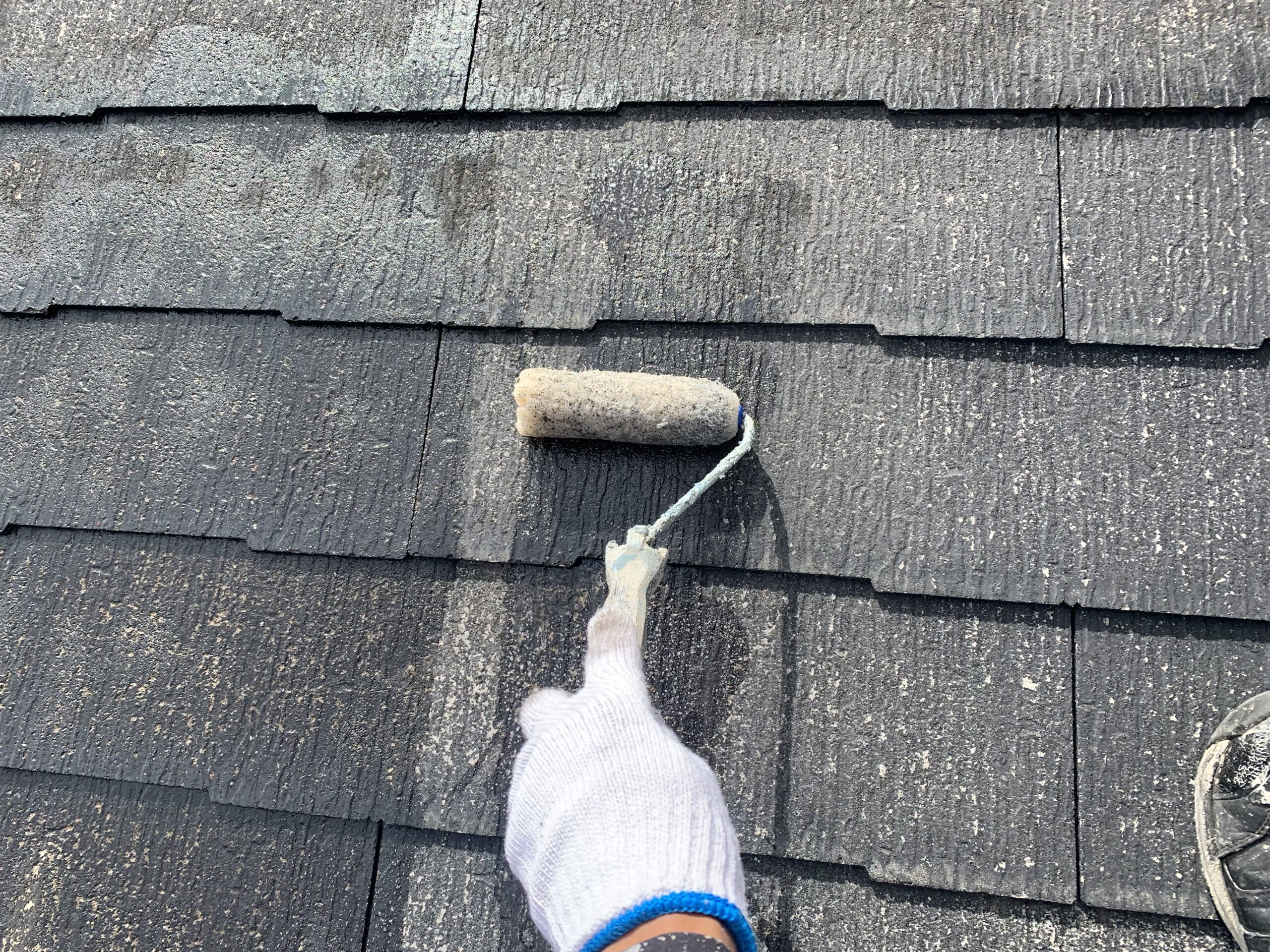 屋根の下塗りをしている写真