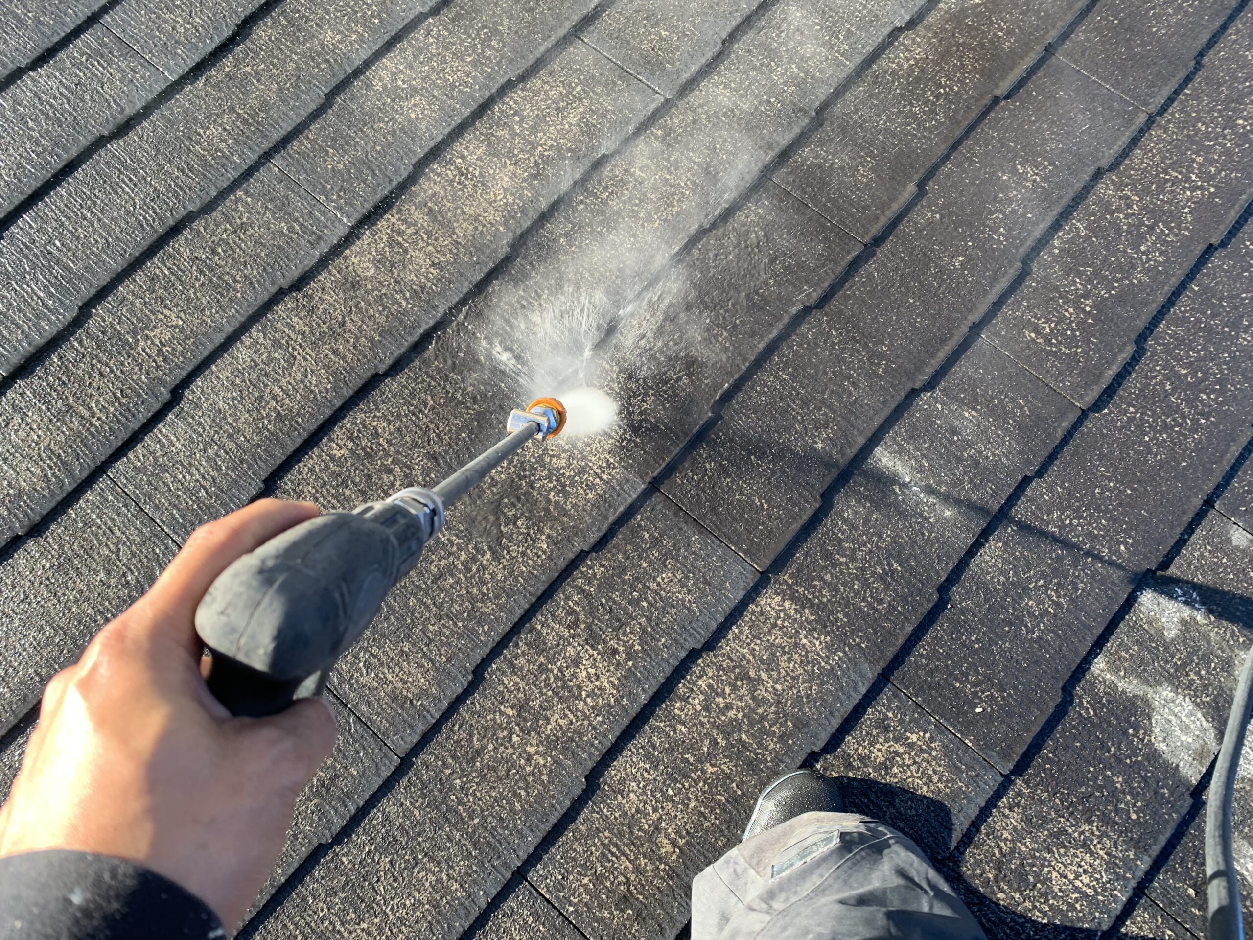 屋根の高圧洗浄をしている写真