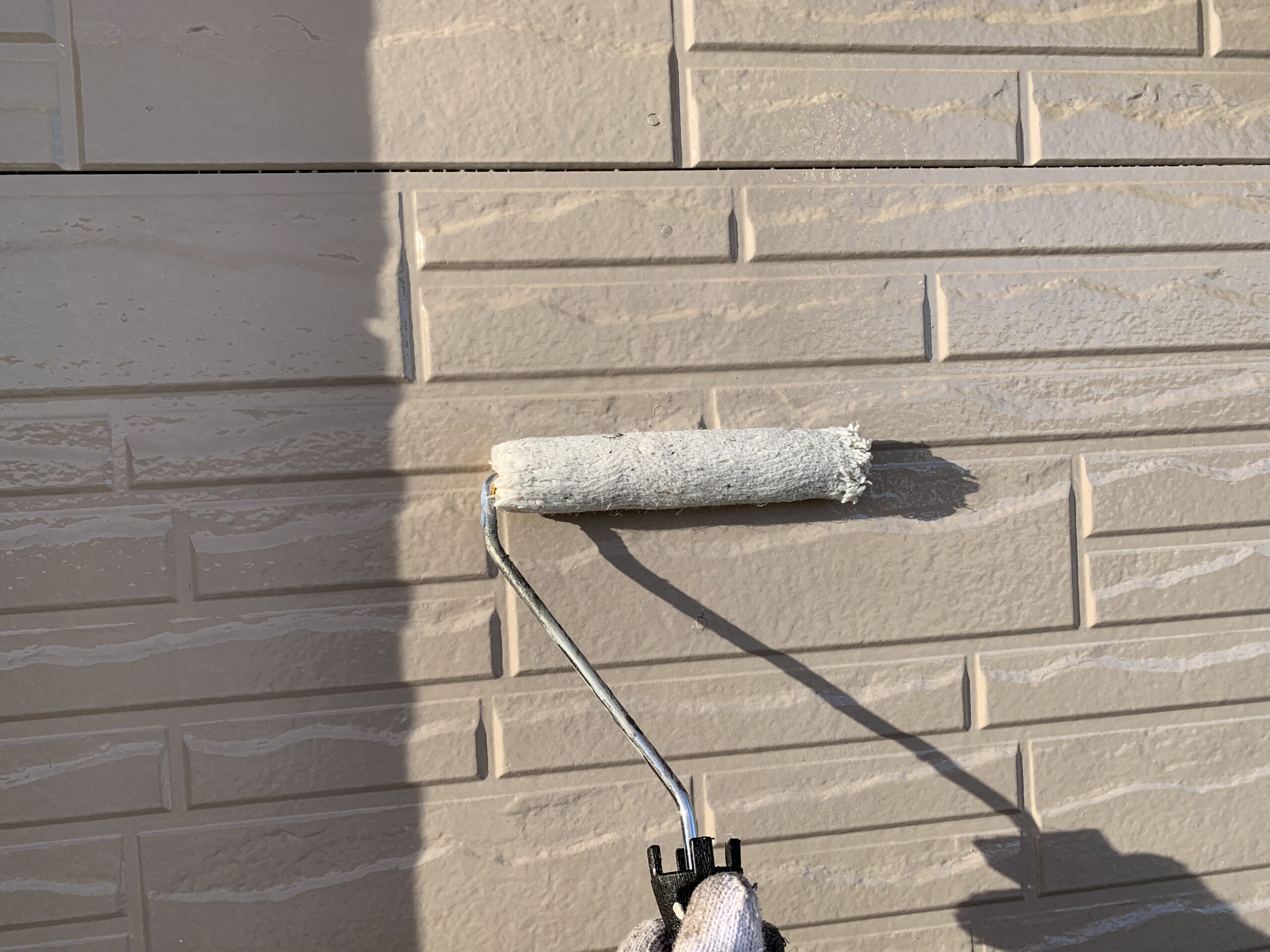 外壁の下塗りをしている写真