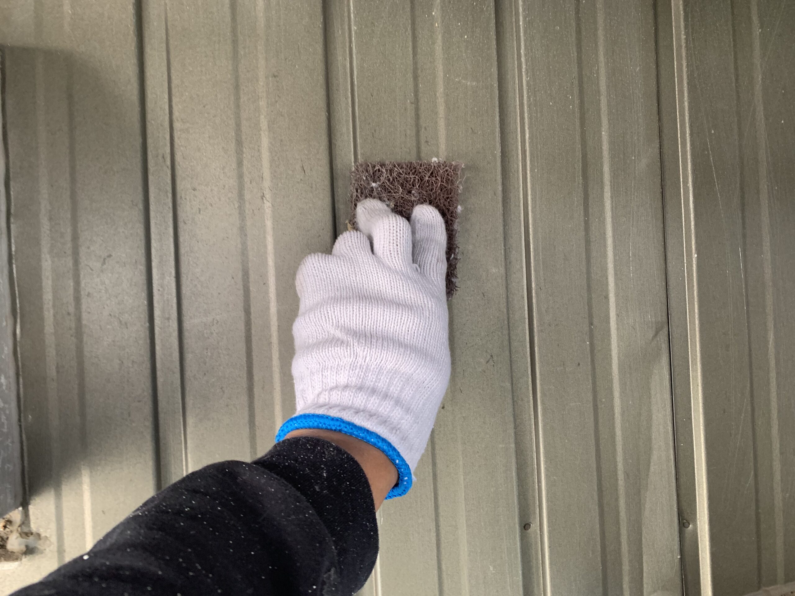 外壁をケレンしている写真