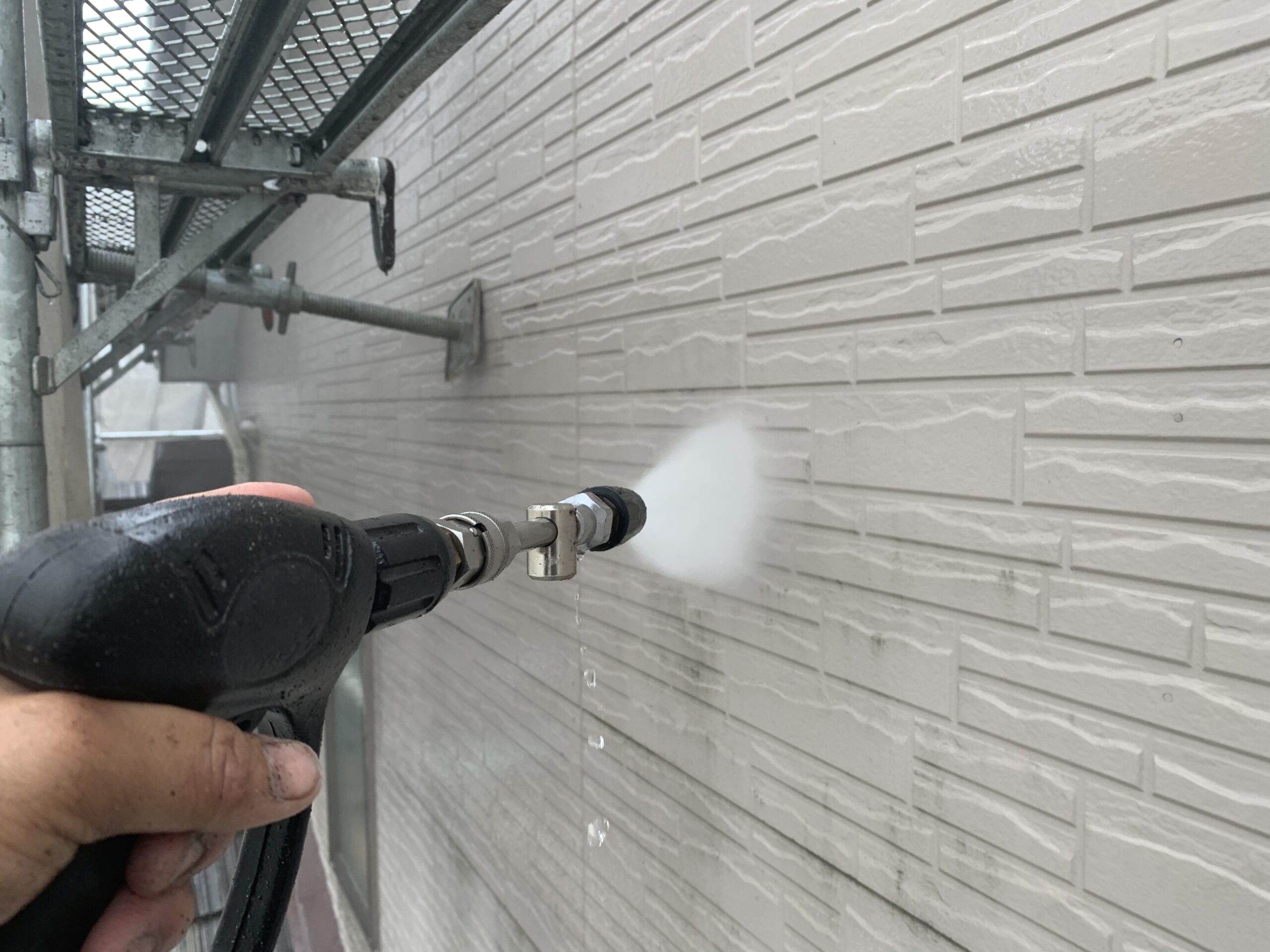 外壁の高圧洗浄をしている写真