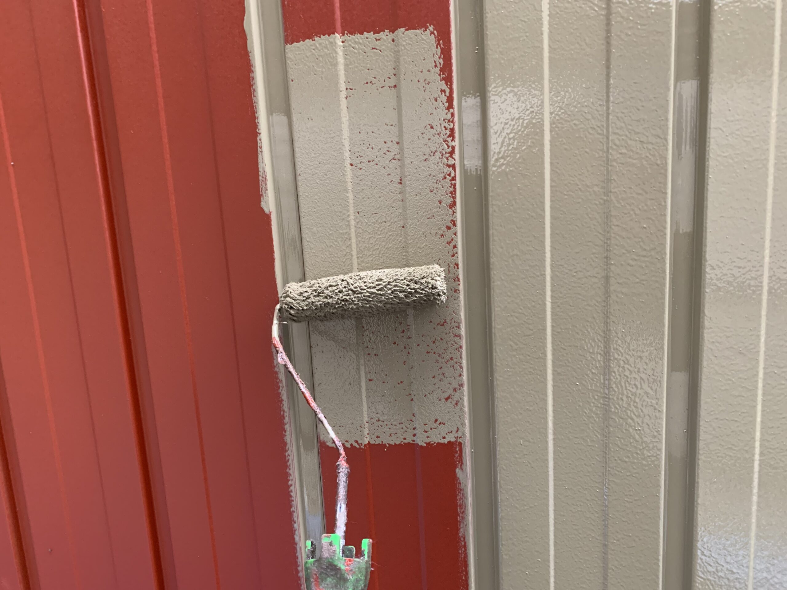 外壁の上塗り１回目を塗っている写真