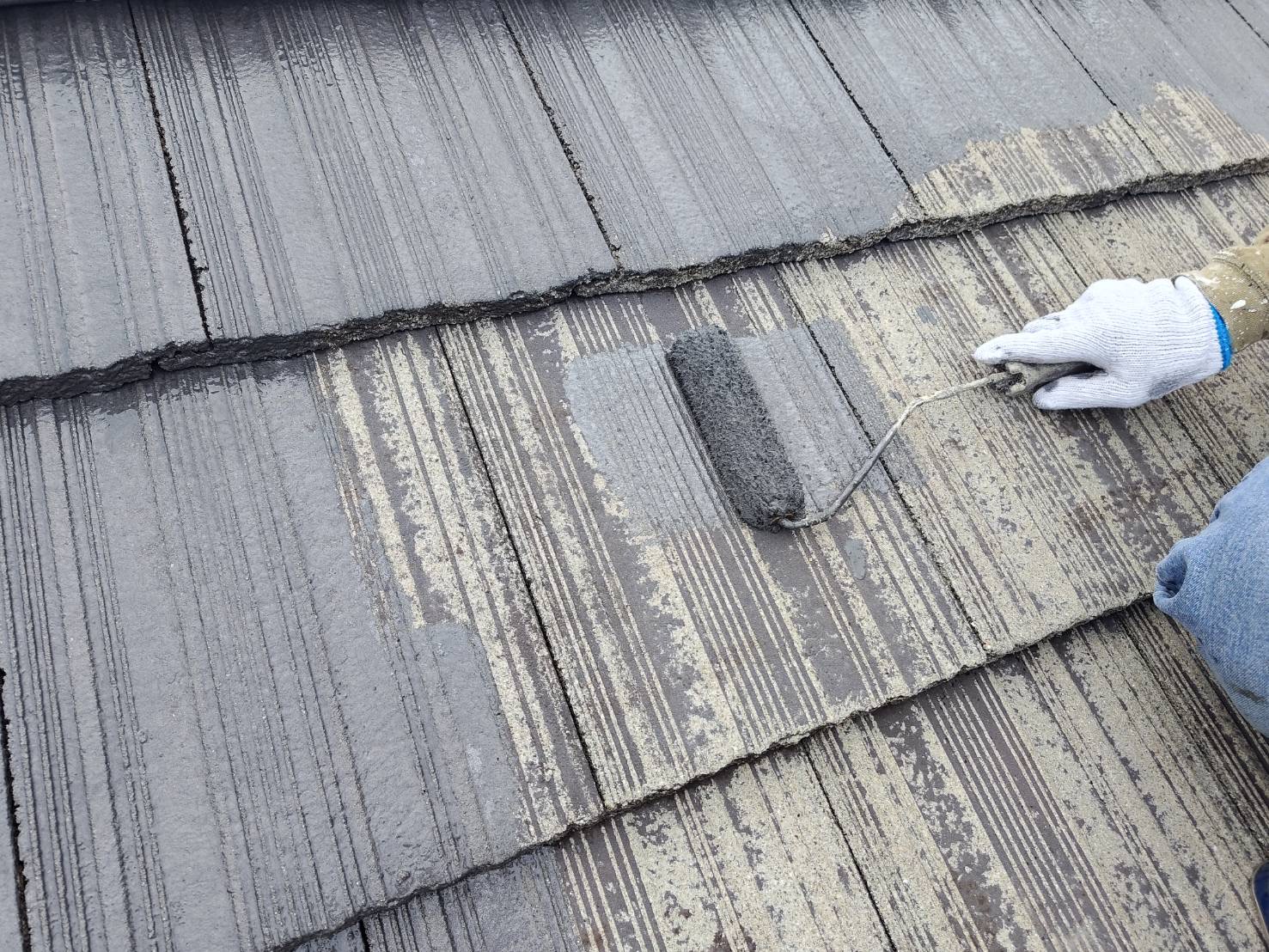 屋根の上塗り１回目を塗っている写真