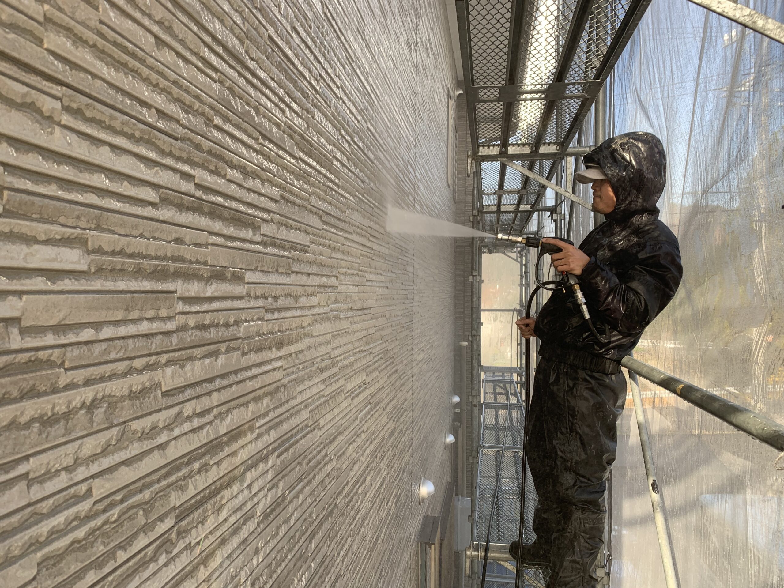 外壁の高圧洗浄をしている写真