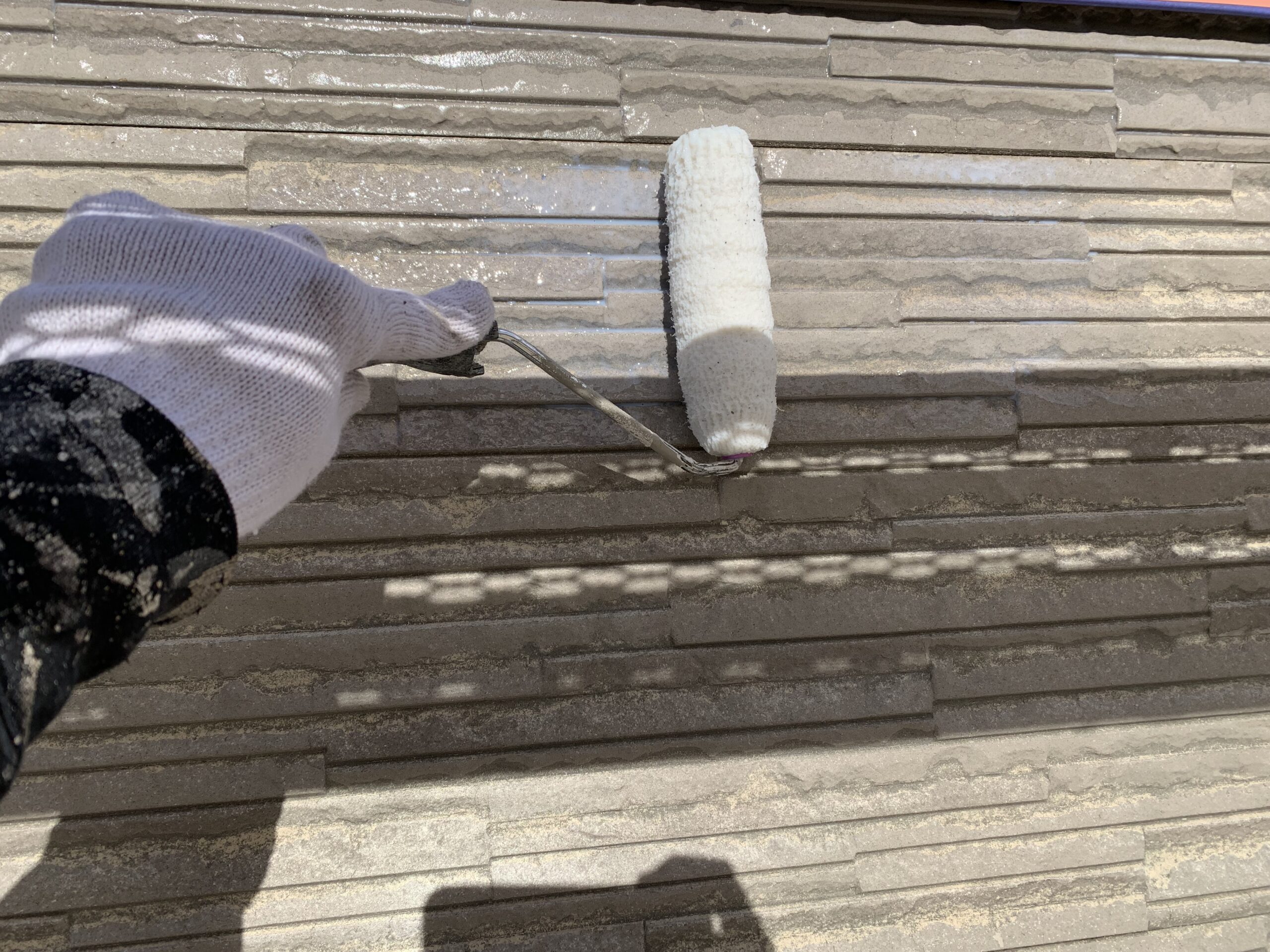 外壁の下塗りをしている写真