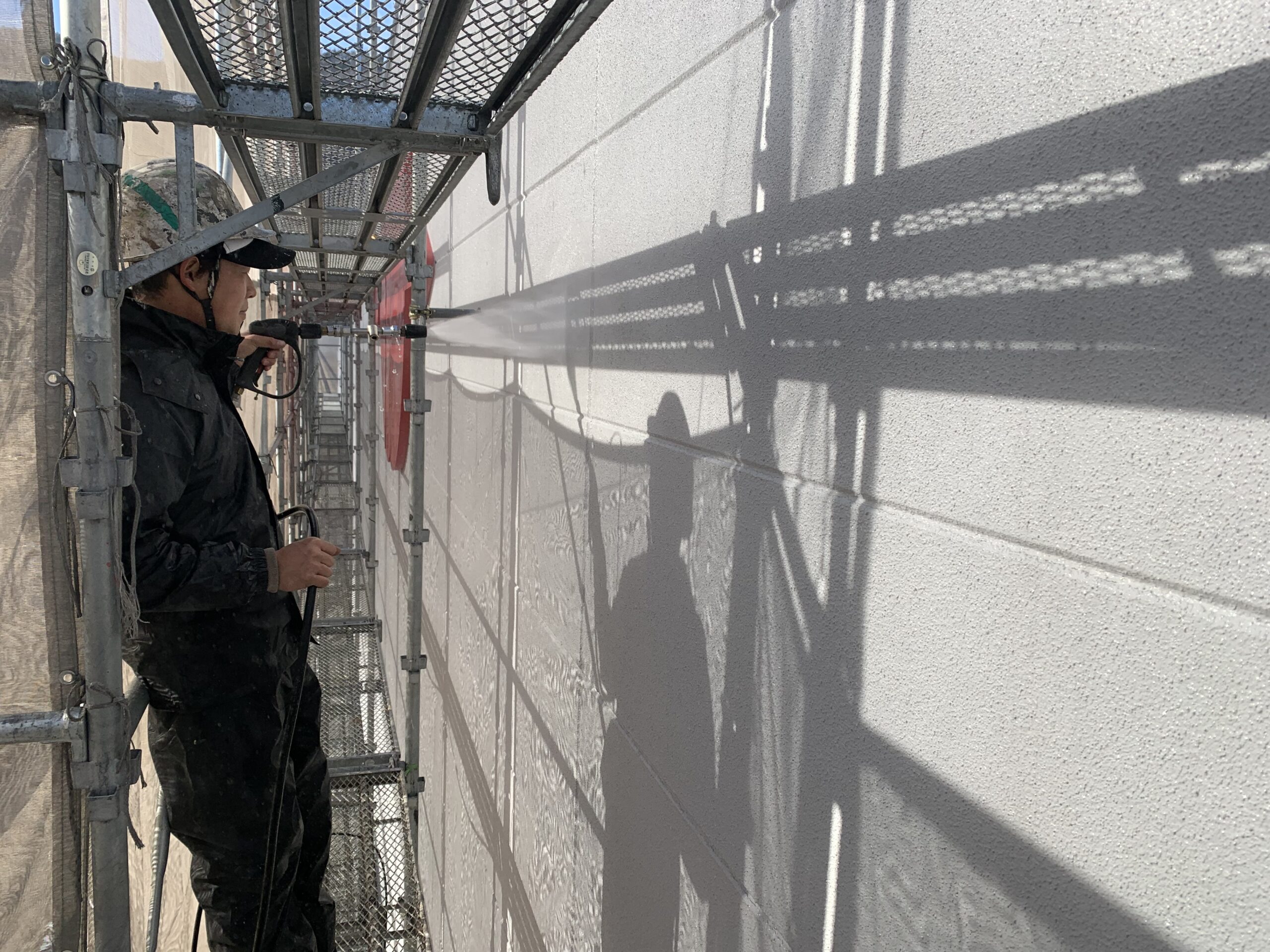 外壁の高圧洗浄をしている写真