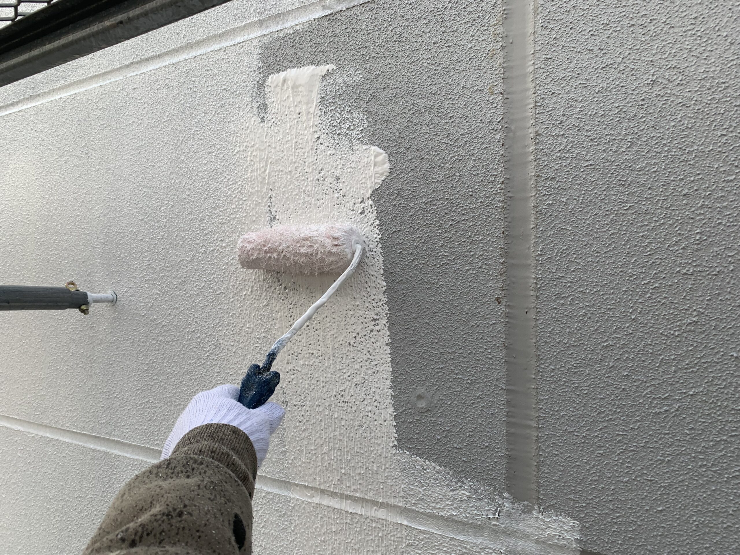 外壁の下塗りをしている写真